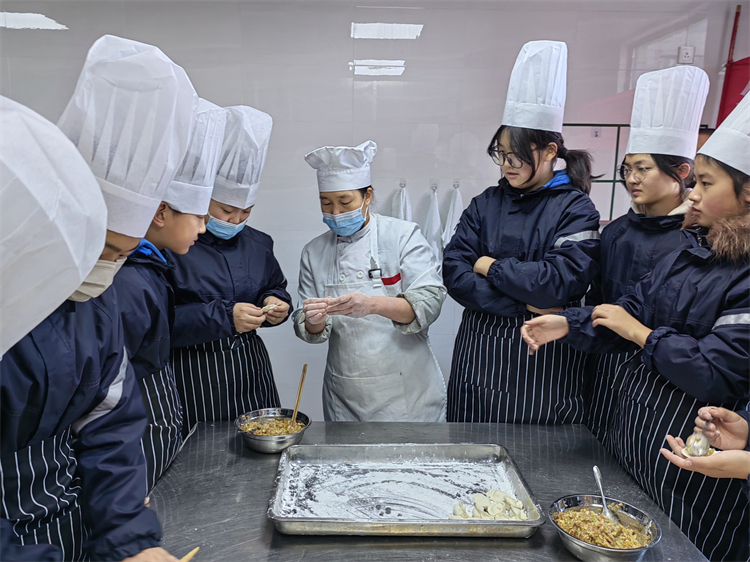 图片1：学生们认真向餐厅师傅学习包饺子.jpg