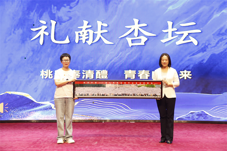 图8：王学娟老师向学校献上全家福.JPG